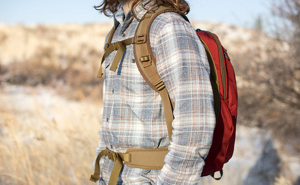 A profile shot of a person wearing the Guide's Edition Synapse 25 with the sternum strap buckled and using the optional padded hip belt.